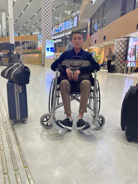 Bekzod in aeroporto in sedia a rotelle